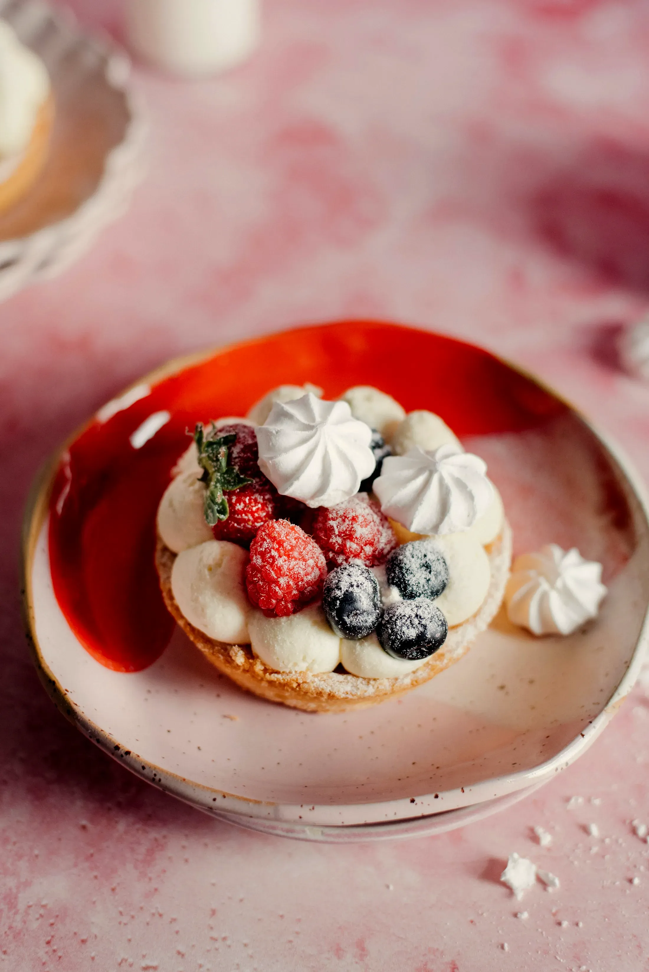 La crostata ai frutti rossi sul piatto rosso
