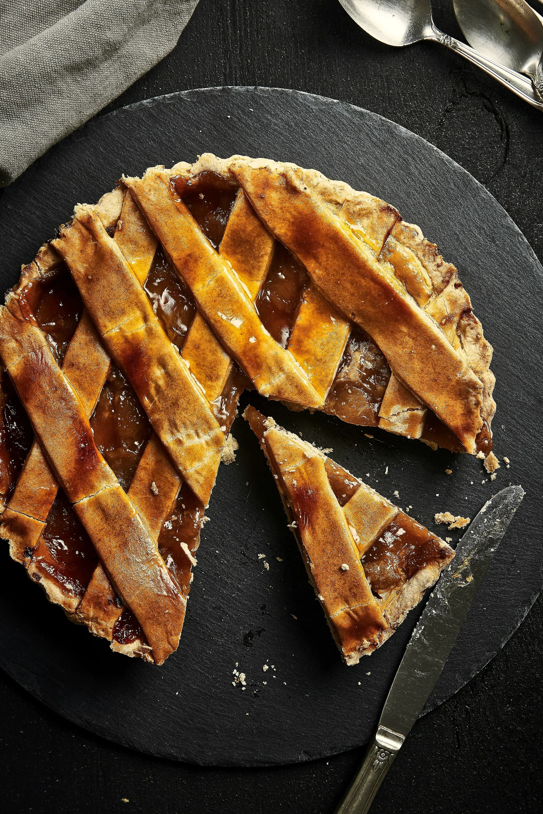 La crostata con la griglia di frolla e la confettura, su fondo scuro