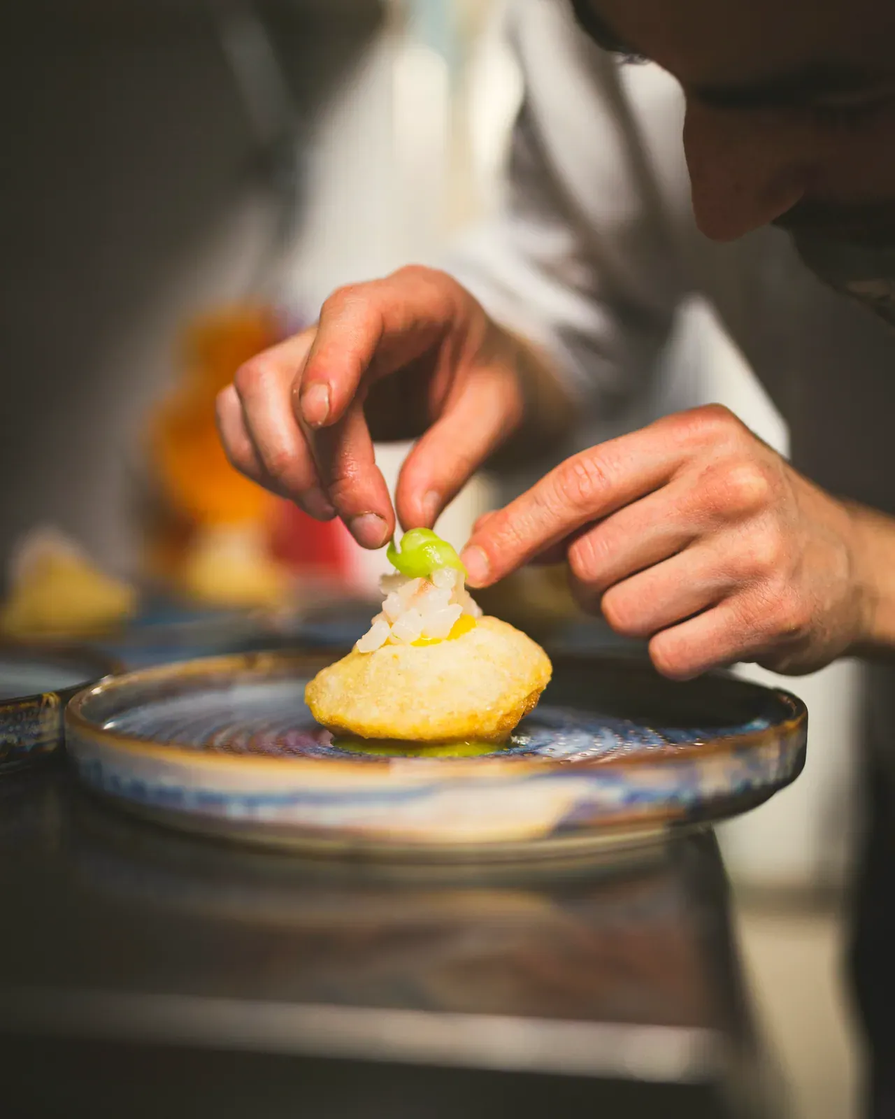 Le mani che finiscono un dolce con le pinze, in laboratorio
