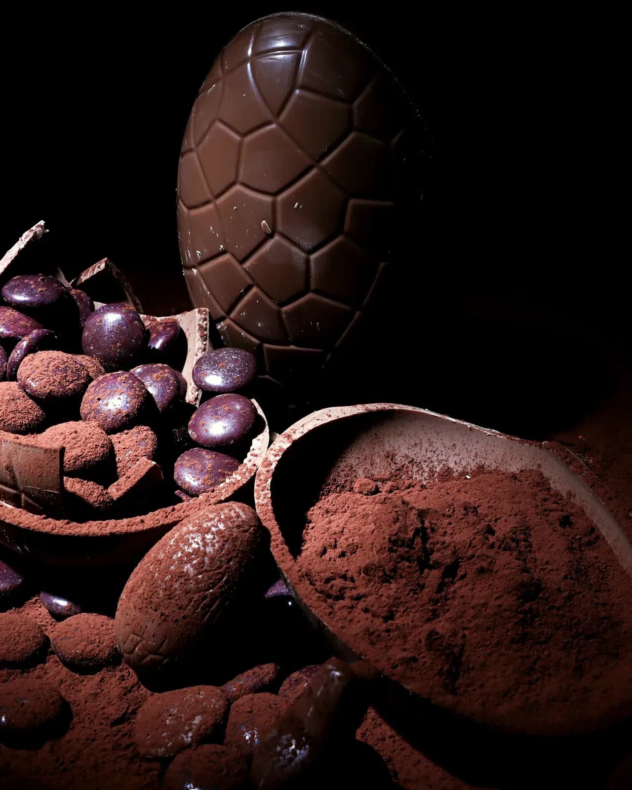 L'uovo di cioccolato fondente aperto, sul fondo nero