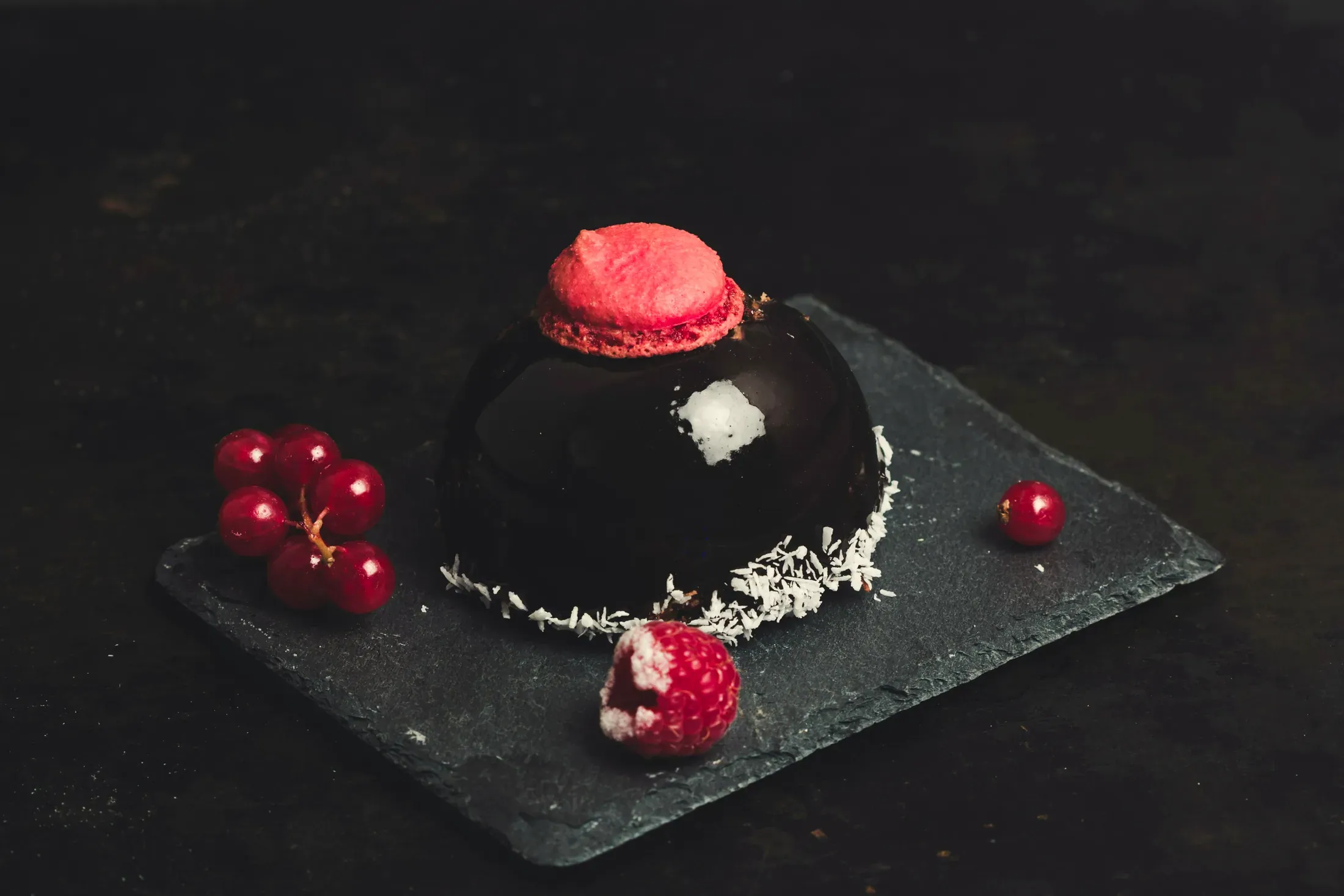 La sfera glassata al cioccolato con il ribes e il cocco