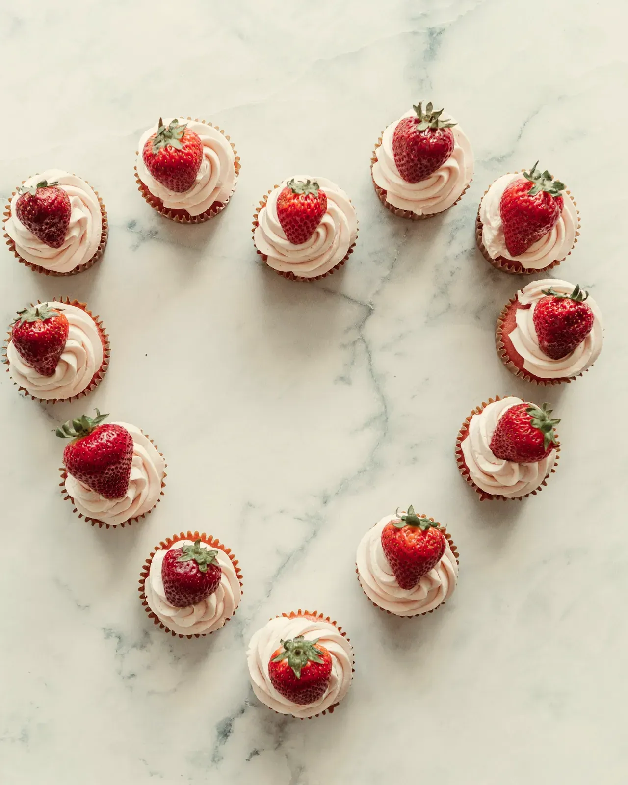 Le tartellette con le fragole disposte a cuore, sul marmo