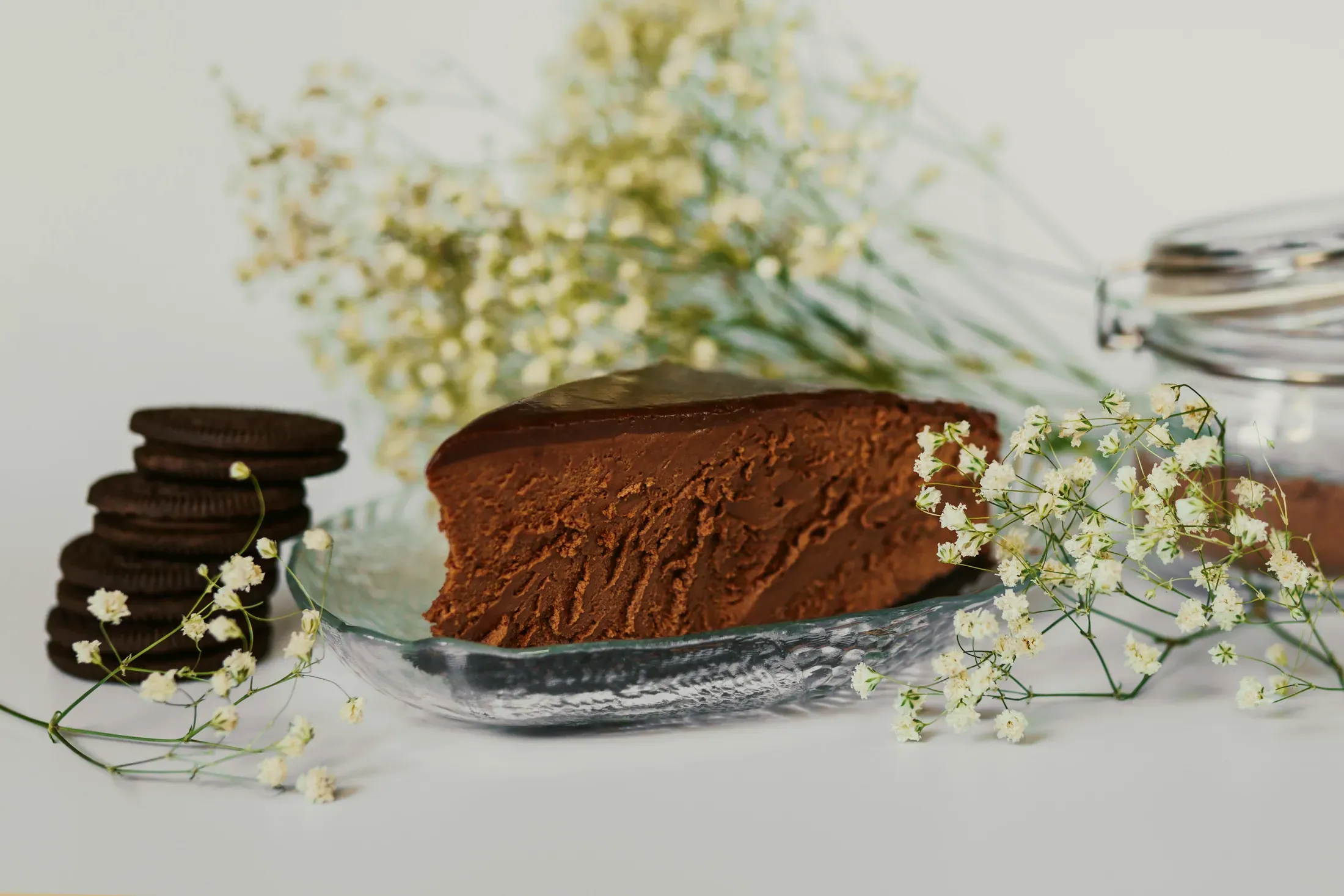 La torta al cioccolato con i fiori bianchi accanto
