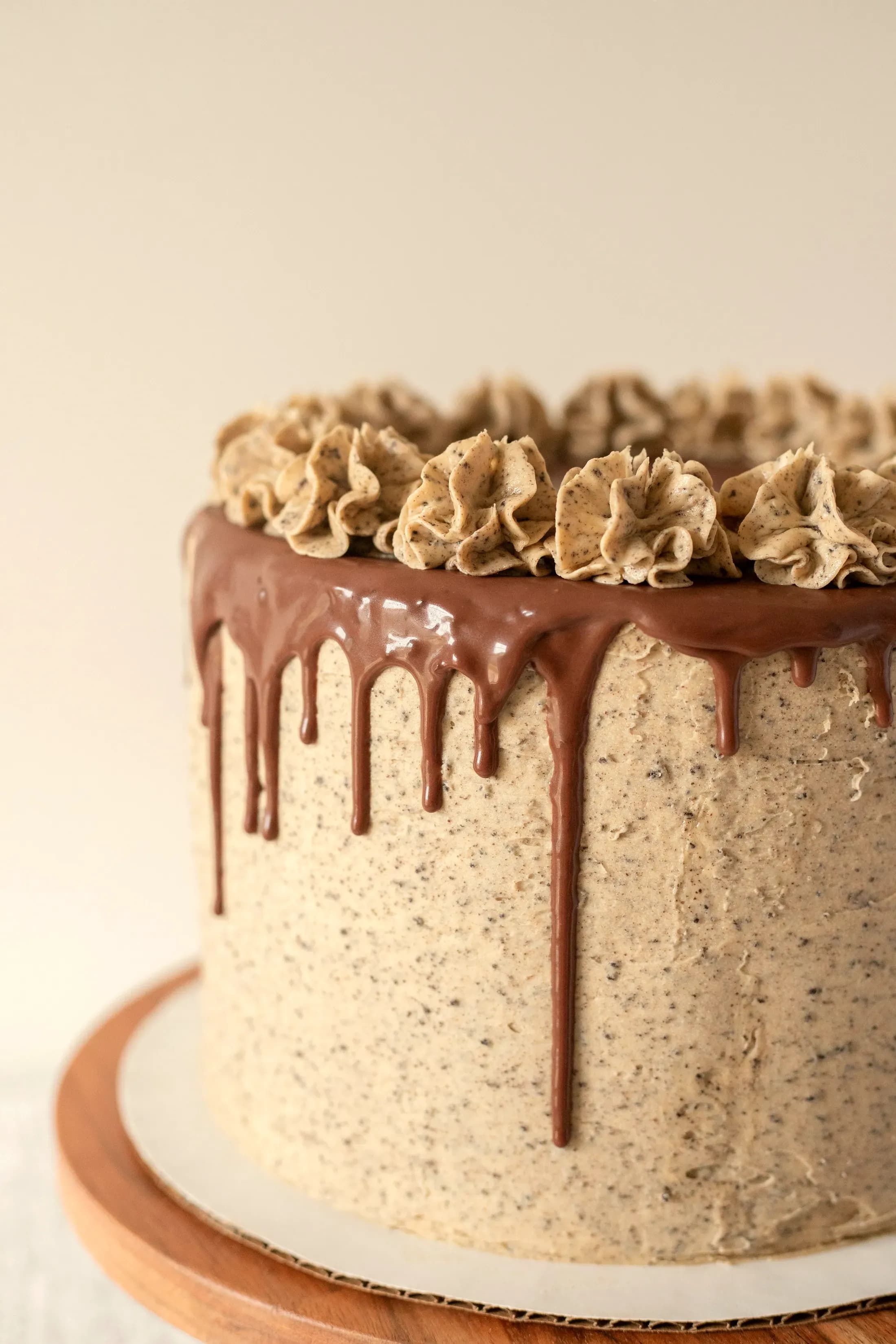 La torta alla nocciola con la colata di cioccolato e i ciuffi di crema