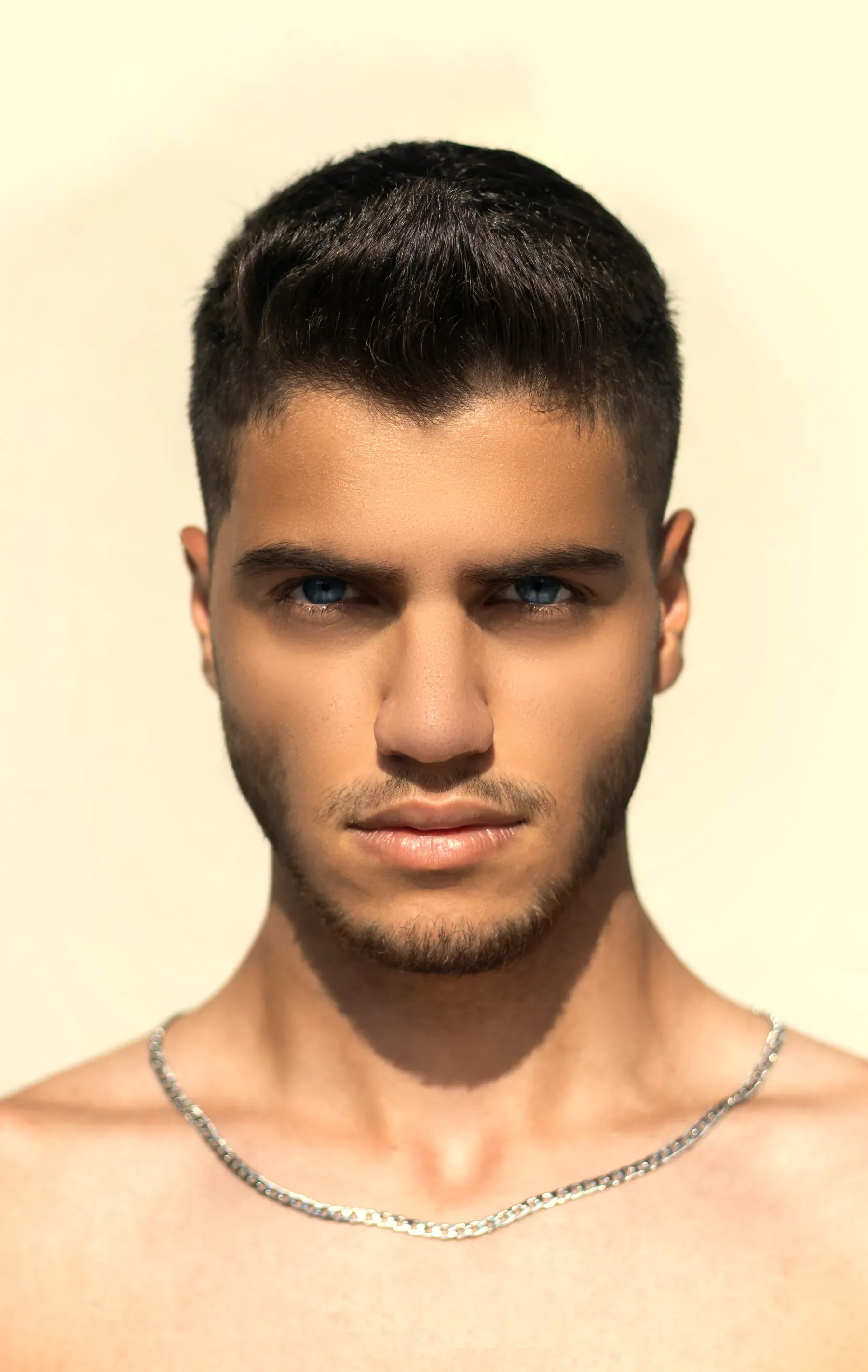 Taglio corto pulito, viso rasato, sguardo dritto