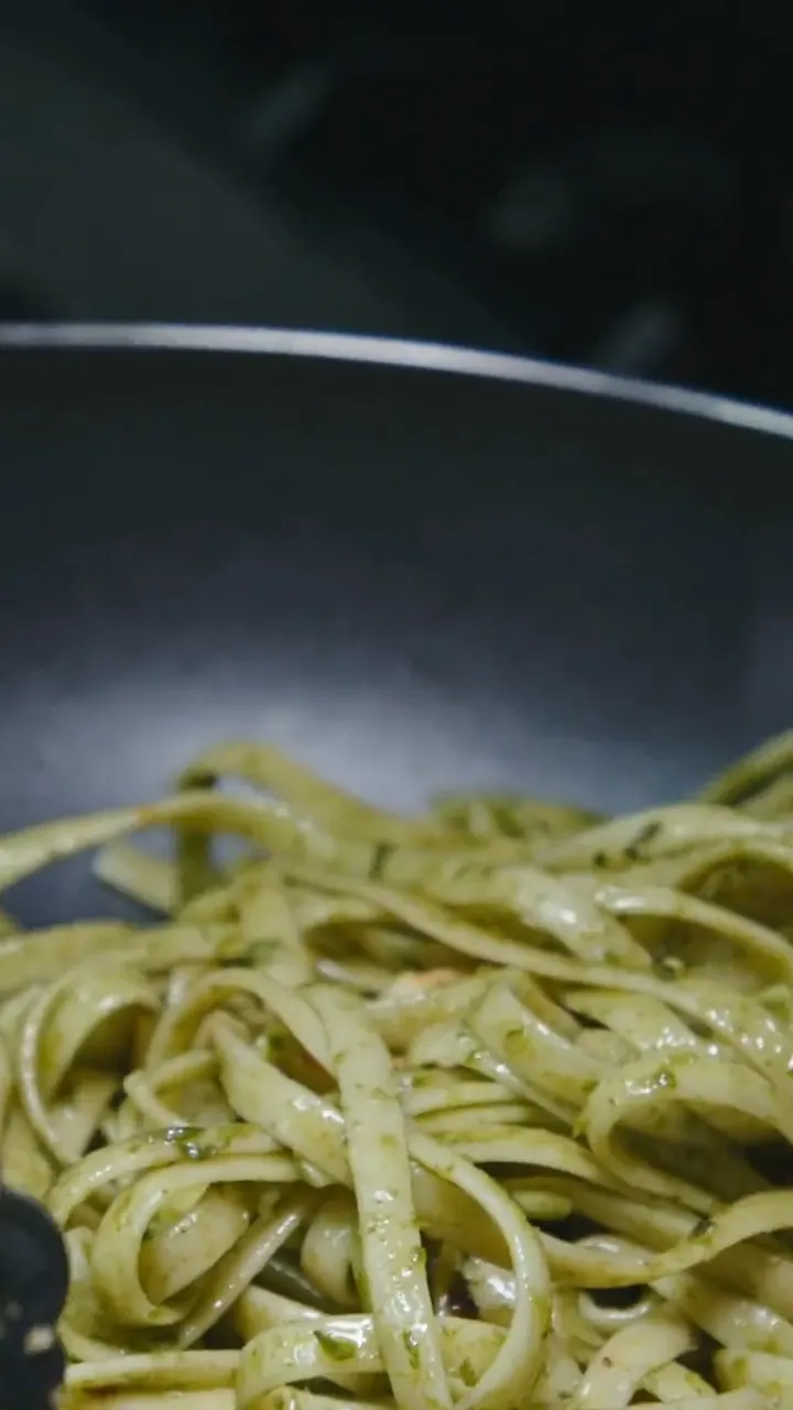 La pasta presa con le pinze dalla padella, da vicino