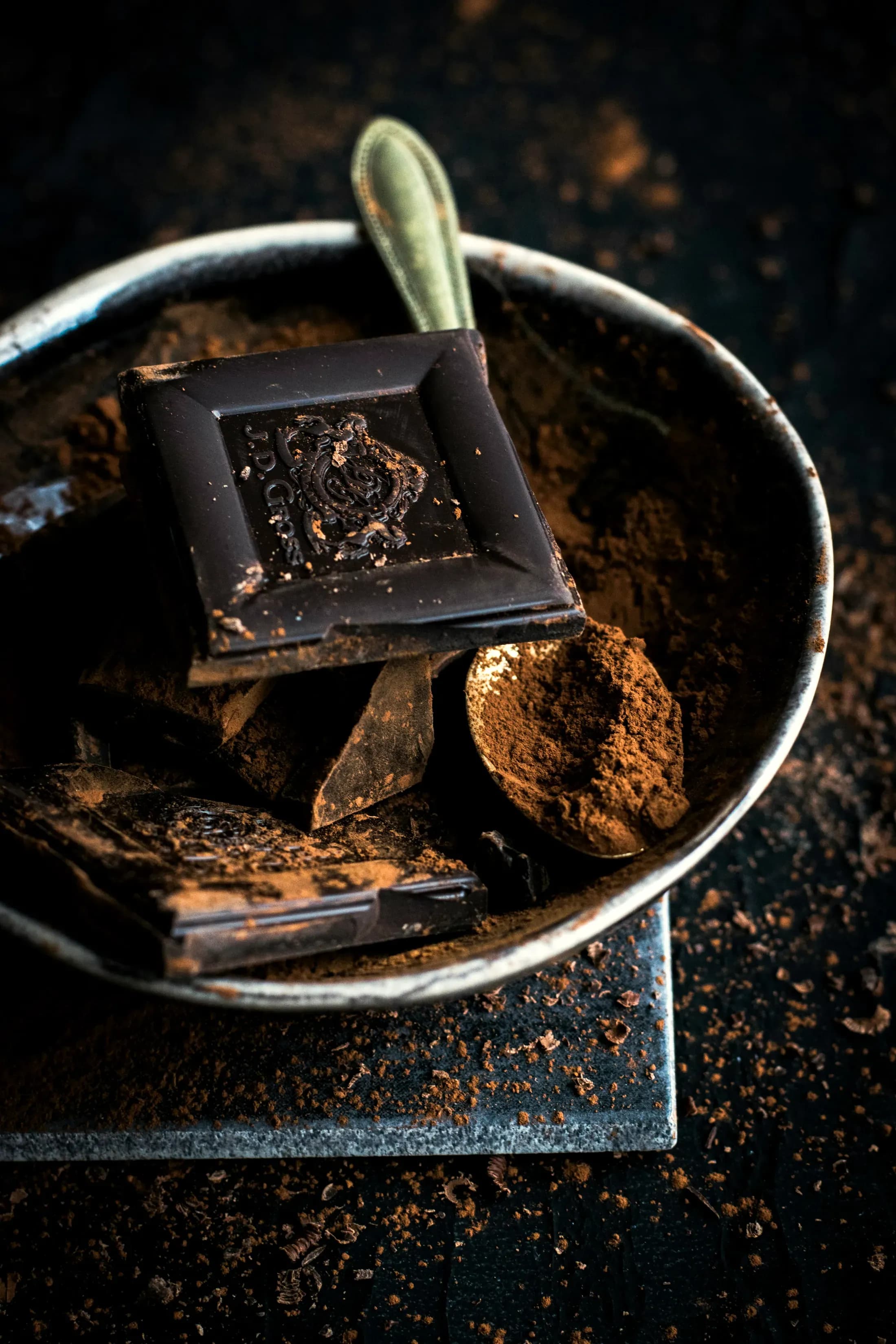 Pezzi di cioccolato fondente in una ciotola con il cacao