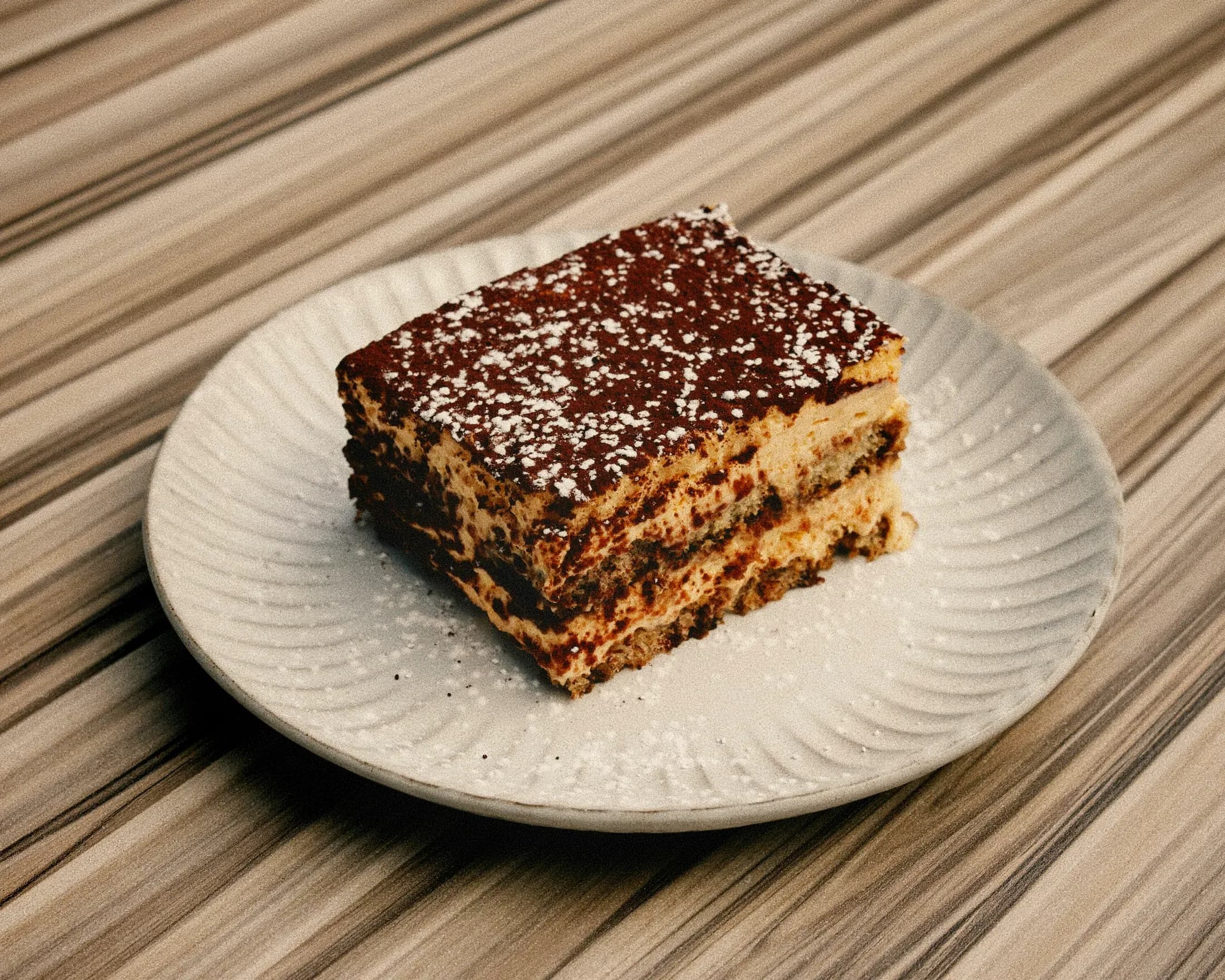 Il tiramisù sul piatto bianco, con il cacao